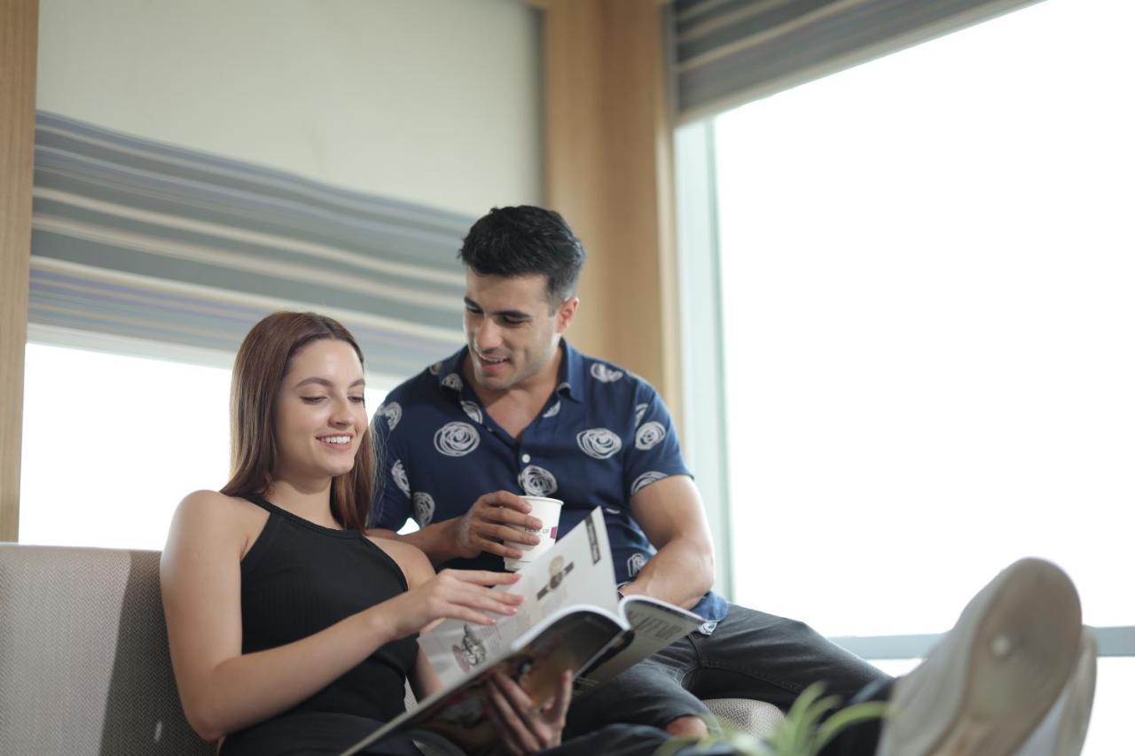 Aloft New Delhi Aerocity Exterior foto A couple reading a magazine